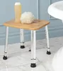 A shower stool with a bottle of liquid and a bath pouf on top, placed on a tiled floor next to a bathtub. Anteprima dell’immagine prodotto