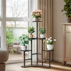 A multi-tiered plant stand filled with various potted plants is placed indoors near a large window with sheer curtains. Náhľad obrázku produktu