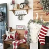 A cozy Christmas-themed entryway with a wooden bench, festive pillows, blankets, stockings, and decorations. Produktbild-Vorschau