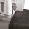 Close-up of a sewing machine's needle and thread stitching the edge of a dark fabric. Náhľad obrázku produktu