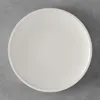 A white plate on a gray concrete background. Podgląd zdjęcia produktu