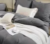 A neatly made bed with gray bedding, a white blanket, and decorative pillows. Podgląd zdjęcia produktu