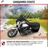 A motorcycle covered by a black tarp, shown in a landscape that transitions through different seasons. Produktbild-Vorschau