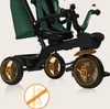 Close-up view of a green and black children's tricycle, highlighting its wheels and frame. Produktbild-Vorschau