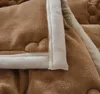 A close-up view of a folded brown blanket with a white trim. Produktbild-Vorschau