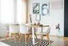 A dining room with a table and chairs, decorated with artwork and flowers. Anteprima dell’immagine prodotto