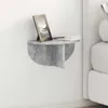 A gray concrete-effect floating shelf mounted on a white wall next to a bed. Produktbild-Vorschau