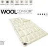 A cream-colored winter blanket with a diamond-stitched pattern is laid out on a white background. Text and icons are displayed above the blanket. Produktbild-Vorschau