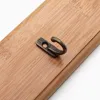 A single metal hook with a bronze finish is attached to a wooden plank. Podgląd zdjęcia produktu