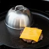 A burger being cooked on a griddle with a cheese slice and a steaming dome. Náhled obrázku produktu