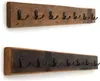 Two wooden coat racks with metal hooks mounted on a white wall. Náhled obrázku produktu