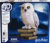 The product packaging for a Harry Potter 4D-Build Hedwig model kit, featuring a depiction of Hedwig perched on books against a night sky. Produktbild-Vorschau