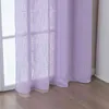 A close-up view of a lilac-colored sheer curtain hanging in front of a window. Produktbild-Vorschau