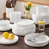 A collection of white ceramic dishes, lemons, and tulips on a wooden table. Produktbild-Vorschau