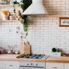 A clean and bright kitchen scene featuring a white brick backsplash, a stainless steel range hood, and a wooden countertop with various kitchen items. Produktbild-Vorschau