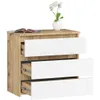 A three-drawer chest of drawers with a wood-effect finish and white drawer fronts, topped with a vase of white flowers and an open book. Produktbild-Vorschau