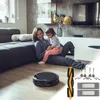 A mother and child are sitting on the floor next to a sofa, with a robot vacuum cleaner and accessories in the foreground. Produktbild-Vorschau
