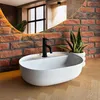 A modern bathroom sink with a black faucet, set against a brick wall and a large mirror. Náhled obrázku produktu