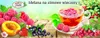 A collection of fruits and a cup of tea, set against a soft, blurred background of greenery and sky. Produktbild-Vorschau