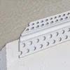 A close-up view of a white PVC corner profile used in drywall construction, installed on an external corner. Produktbild-Vorschau