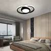 A modern bedroom with a bed, chairs, and a large window overlooking a city. Produktbild-Vorschau
