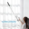 A woman is using a white stick vacuum cleaner against a white curtained background. Produktbild-Vorschau