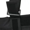 A close-up view of black fabric with velcro straps and a plastic buckle, likely part of a garment. Produktbild-Vorschau
