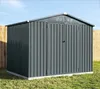 A dark gray metal shed with double doors, set on a concrete base in a grassy yard, with a wooden fence on either side and a blue sky above. Podgląd zdjęcia produktu