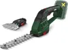A cordless grass and shrub shear with interchangeable blades, shown with the shrub shear blade attached and the grass shear attachment to the side. A dashed outline with a yellow 'X' highlights the battery area, indicating it is not included. Produktbild-Vorschau
