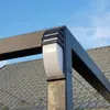 Close-up of an outdoor wall light attached to a dark metal structure, with a grey tiled roof and blue sky in the background. Produktbild-Vorschau