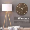 A wall clock with a floor lamp and a sofa in the background. Produktbild-Vorschau