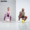 A man and a woman performing kettlebell squats in a gym. Produktbild-Vorschau