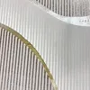 A close-up view of a textured fabric with a striped pattern and a curved metallic gold accent. Produktbild-Vorschau