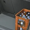 The image shows the interior of a car trunk with a gray anti-slip mat and a crate of bottled water. Voir les images du produit