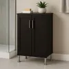 A dark brown cabinet with silver legs and handles stands on a tiled floor next to a shower enclosure. Two white and yellow blocks and a potted plant are on top of the cabinet. Produktbild-Vorschau