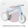 A light blue and white balance bike for children, presented against a light purple and white background. A feather icon is visible in the top left corner. Voir les images du produit