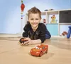 A young boy is lying on the floor playing with a remote-controlled toy car. Anteprima dell’immagine prodotto