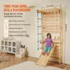 A young girl is playing on a wooden indoor playground structure attached to a wall, with text describing the benefits of the playground. Podgląd zdjęcia produktu
