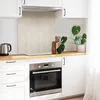 A modern kitchen counter with a stovetop, oven, and cabinets. There are decorative items like cutting boards and a plant. Produktbild-Vorschau