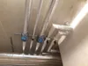 Pipes with insulation and valves attached to a ceiling. Produktbild-Vorschau