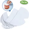 A hand is shown placing a denture adhesive pad onto a set of dentures. A pile of denture adhesive pads is fanned out in the foreground. Produktbild-Vorschau