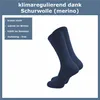 A pair of navy blue socks is shown against a white background, with text describing their features. Produktbild-Vorschau