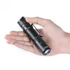 A hand holding a black LED flashlight against a white background. Produktbild-Vorschau