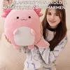 A young woman is holding a large pink axolotl plush toy. Produktbild-Vorschau