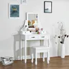 A white vanity table with a mirror and stool, decorated with makeup and a vase of branches. Produktbild-Vorschau