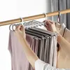A person is organizing multiple pairs of pants on a multi-tier hanger. Anteprima dell’immagine prodotto