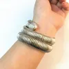 A close-up shot of a silver-colored bracelet on a person's wrist. Podgląd zdjęcia produktu