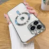 A hand holding a clear phone case with a silver metallic ring around the camera lens and a silver ring around the Apple logo. Produktbild-Vorschau