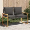 A garden bench with cushions is placed on a paved patio in front of a wooden fence and some greenery. Anteprima dell’immagine prodotto