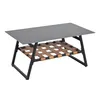 A coffee table with a gray top and a woven brown shelf underneath, supported by black metal legs, isolated on a white background. Voir les images du produit